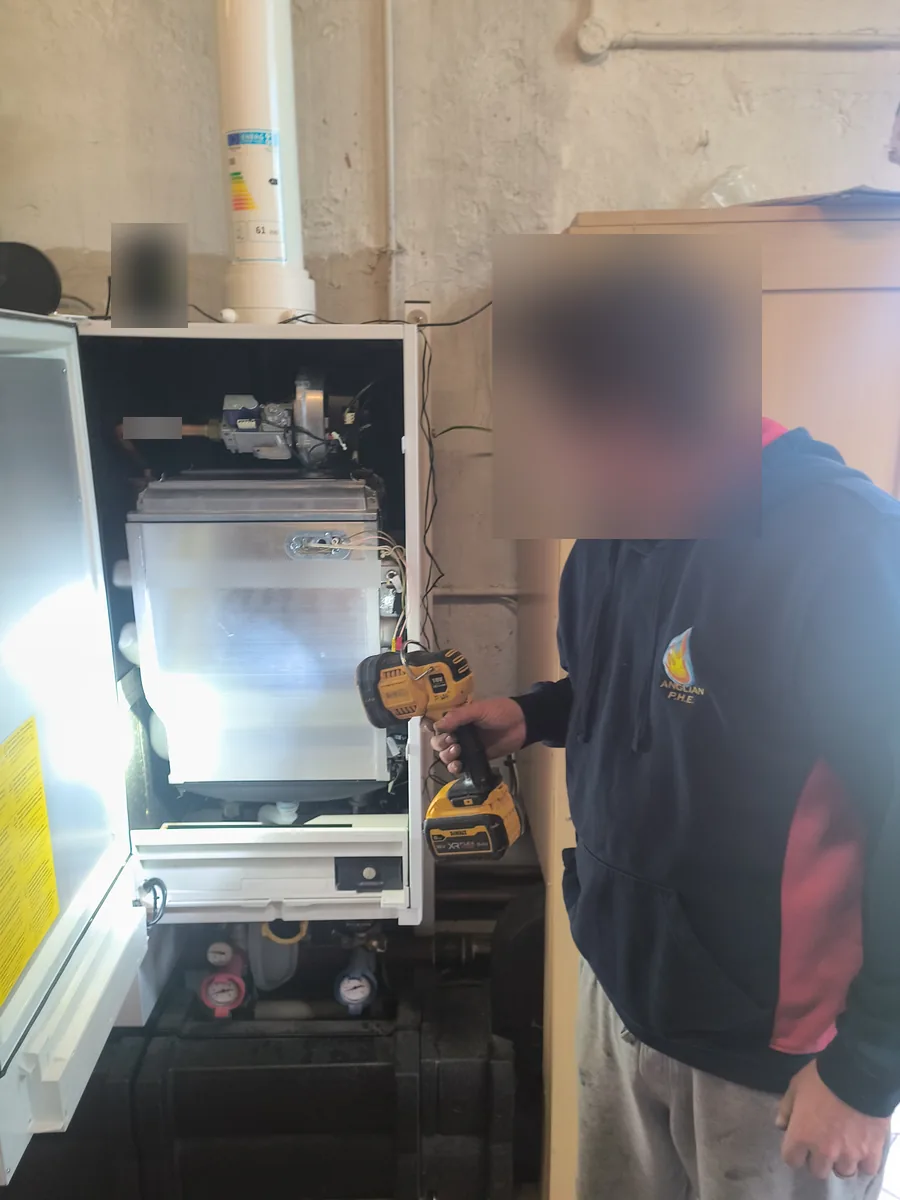 Gas Safe engineer working on an open commercial condensing boiler in a Haverhill church