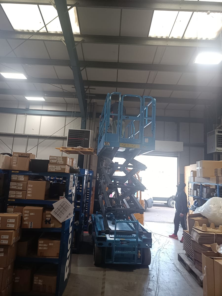Scissor lift work on a wall-mounted commercial heater