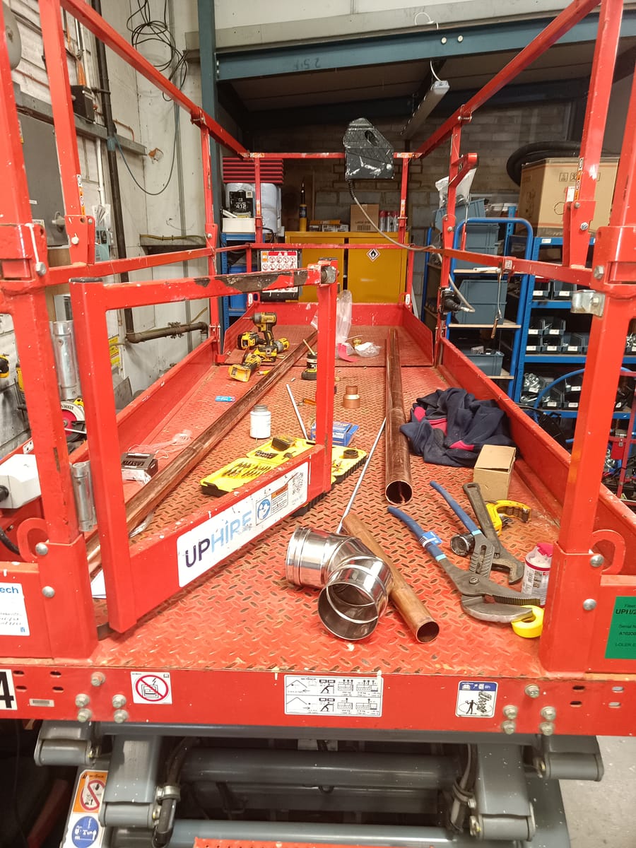 Scissor lift platform with copper pipework and tools